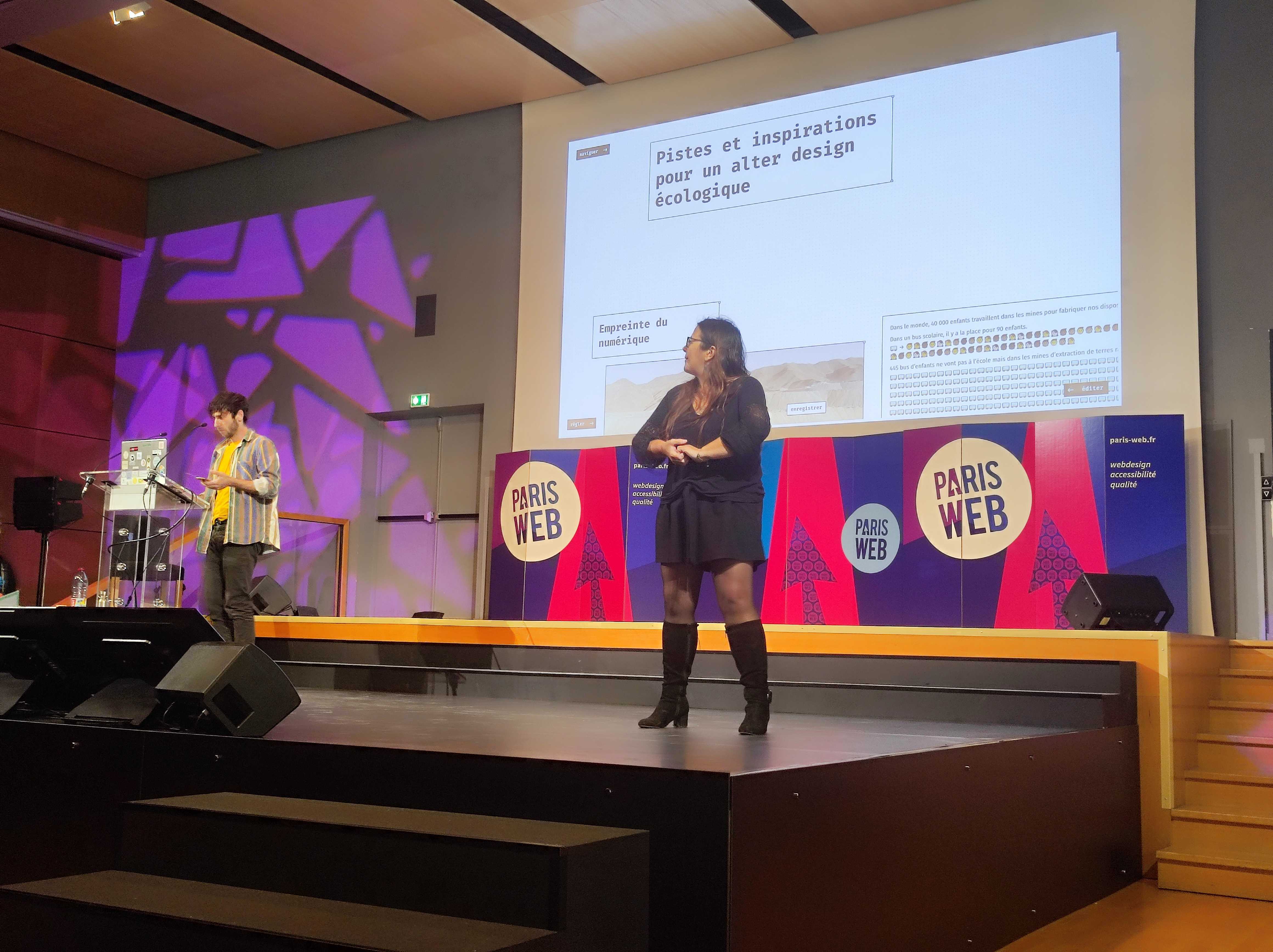 Thomas Thibault devant sa présentation pour "Quel design pour un numérique écologiquement contraint ?". Comme pour chaque conférence une interprète LSF est présente.